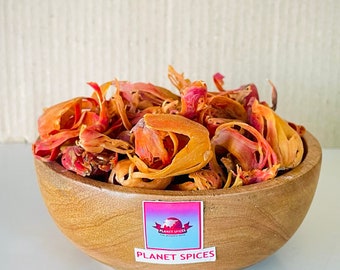 Puede incluir: Un bol de madera lleno de especias de macis secas, de color naranja y rojo. El bol tiene una etiqueta que dice "Planet Spices".