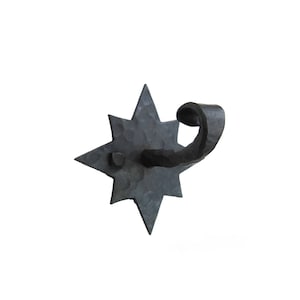 May include: Black metal star-shaped wall hook with a curled hook arm.