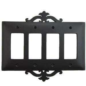 May include: Black metal 4-gang switch plate with an ornate design. The plate has a decorative scrollwork design at the top and bottom.