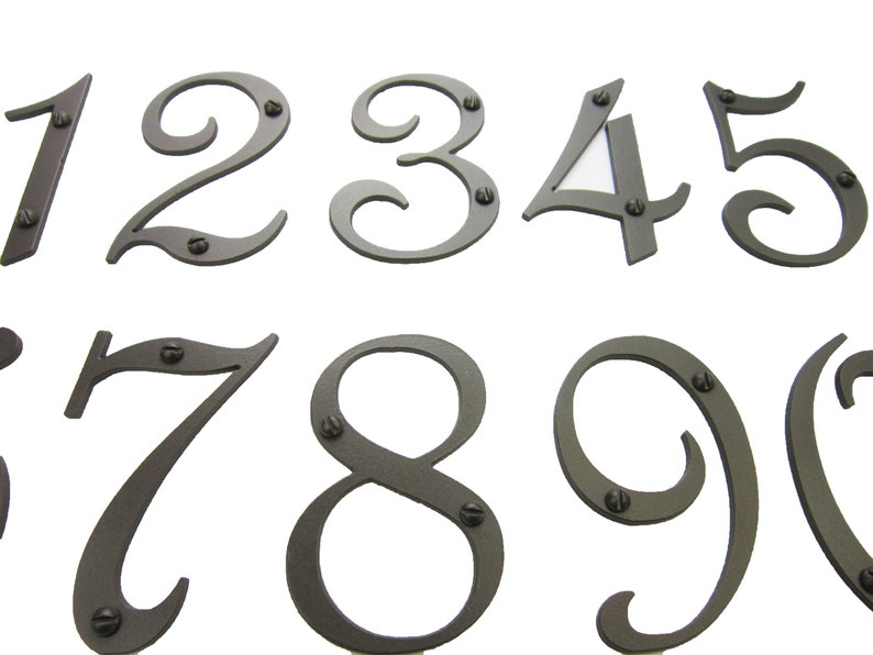 May include: Set of ten metal house numbers in a cursive font. The numbers are painted a dark gray color and have a distressed finish. Each number has two small screws for mounting.