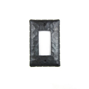 May include: Black metal light switch cover with a hammered texture.