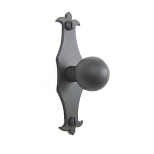 May include: Black metal door knob with a round handle and a decorative backplate with a fleur-de-lis design.
