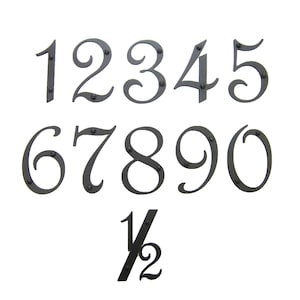 May include: Black metal house numbers 1 through 9 and a half, in a decorative script font. The numbers are attached to a white background.
