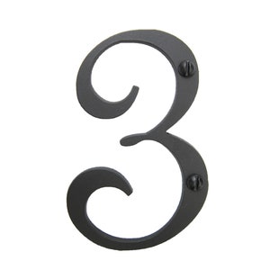 May include: Black metal house number three with a decorative, stylized font. The number is attached to a surface with two screws.