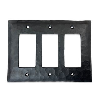 May include: Black metal triple switch plate with a hammered finish. The plate has three rectangular openings for switches or outlets.
