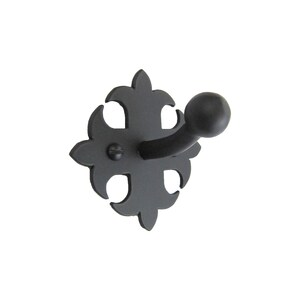 May include: Black metal wall hook with a decorative, ornate design. The hook has a rounded end and is attached to a square base.