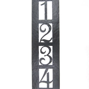 May include: Black metal house number plaque with the numbers 1, 2, 3, and 4 cut out. The numbers are in a decorative font.