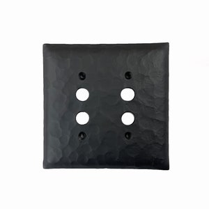 May include: Black hammered metal double switch plate cover with four round openings.