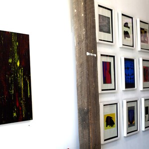 Puede incluir: Una pared de galer&iacute;a con una variedad de impresiones de arte abstracto enmarcadas. Las impresiones son de varios colores, incluyendo rojo, azul, amarillo y negro. Todas las impresiones est&aacute;n enmarcadas en marcos blancos.