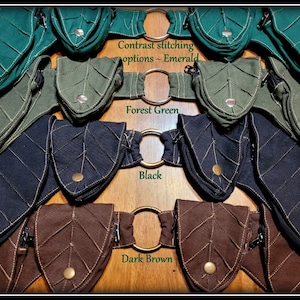 Op de afbeelding: Vier bladeren-vormige zakjes met contrast stiksels in smaragdgroen, bosgroen, zwart en donkerbruin. Elk zakje heeft een ritssluiting en een metalen ring.