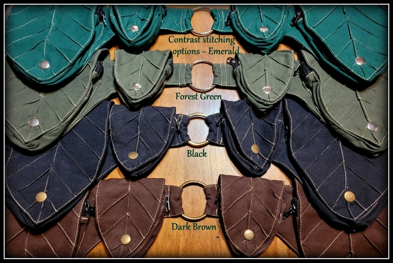 Op de afbeelding: Vier bladeren-vormige zakjes met contrast stiksels in smaragdgroen, bosgroen, zwart en donkerbruin. Elk zakje heeft een ritssluiting en een metalen ring.