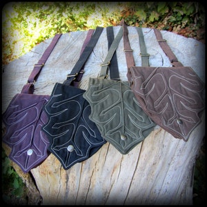 May include: Four leaf-shaped canvas bags with adjustable straps. The bags are in shades of brown, green, and black with white stitching. Each bag has a metal button closure.