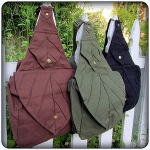 May include: Three canvas shoulder bags with leaf-shaped designs. The bags are brown, green, and black.