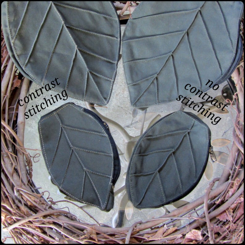 May include: Four leaf-shaped fabric pouches with zippers. Two pouches have contrast stitching, and two pouches have no contrast stitching. The pouches are arranged on a woven surface.