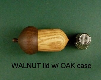 Wood Acorn Thimble Case WALNUT Lid and OAK Case. It measures approximately 2 1/4” long and 1 1/4” in diameter +/- 1/8”.