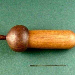 May include: A wooden acorn-shaped box with a dark brown lid and a light brown body.