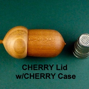 May include: A wooden acorn-shaped box with a lid, made of cherry wood. The box is closed and the lid is on top. A silver thimble is next to the box. The text "CHERRY Lid w/CHERRY Case" is below the box.