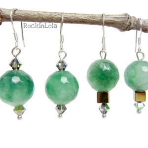May include: Four pairs of green faceted bead earrings with silver hooks. Each earring has a large, round, green bead, a small crystal bead, and a silver accent. Some earrings feature a gold-tone square bead.