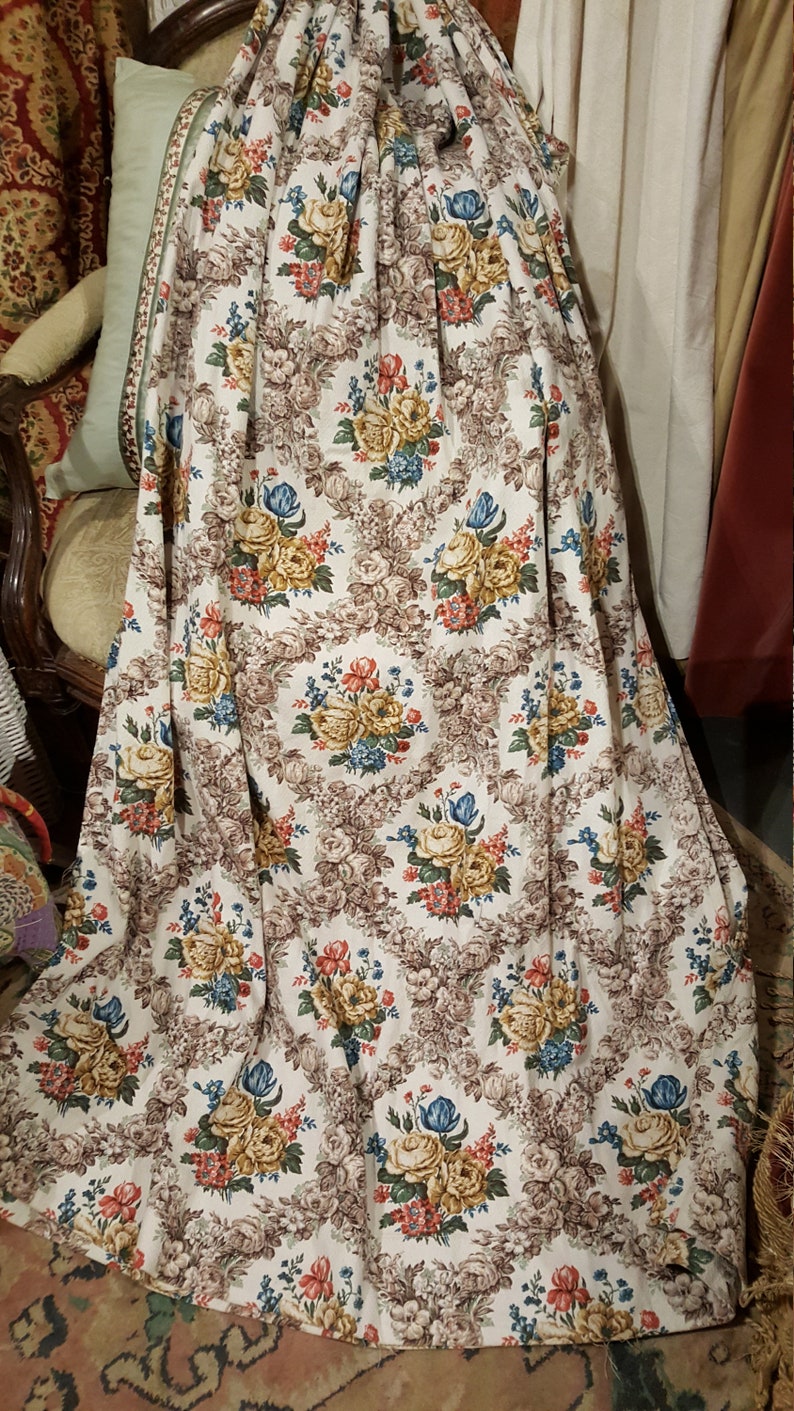 K&ouml;nnte beinhalten: Ein wei&szlig;er Stoffvorhang mit einem braunen Blumenmuster. Das Muster zeigt eine Vielzahl von Blumen, darunter Rosen, G&auml;nsebl&uuml;mchen und Tulpen. Die Blumen sind in den Farben Gelb, Rot, Blau und Gr&uuml;n gehalten.