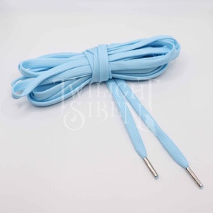 May include: A pair of light blue shoelaces with silver aglets. The shoelaces are made of a soft, woven fabric and are approximately 114 cm long.
