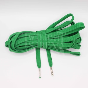 Puede incluir: Cordones de zapatos verdes con aglets plateados. Los cordones est&aacute;n hechos de tejido tejido y miden aproximadamente 100 cm de largo.