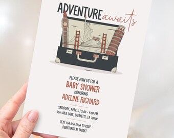 May include: A white baby shower invitation card featuring the text ADVENTURE awaits and an illustration of a black suitcase filled with landmarks including Big Ben, the Statue of Liberty, the Golden Gate Bridge, and the Leaning Tower of Pisa.