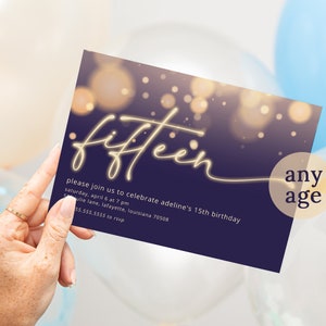 May include: A purple invitation card with gold lettering that says "fifteen" and "any age". The background is a blurred image of golden lights.