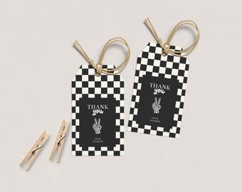 May include: Two gift tags with a black and white checkered pattern border. The center of the tags is black with the words "THANK YOU" and a peace sign hand graphic. The tags have a jute twine loop and are next to two wooden clothespins.