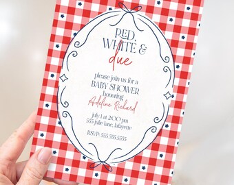 May include: Baby shower invitation with a red and white gingham pattern background. The invitation features the text "RED, WHITE & due" in red script, along with event details in a decorative oval frame. The invitation is held by a hand.