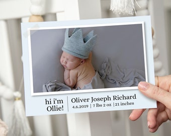 May include: A newborn baby boy wearing a blue knitted crown, sleeping on a gray blanket. The text reads "hi i'm Ollie!" and "Oliver Joseph Richard 4.6.2019 | 7 lbs 2 oz | 21 inches".