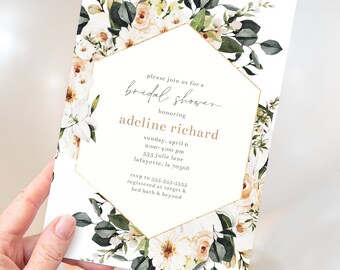 May include: A floral bridal shower invitation featuring a white background with a gold geometric frame. The invitation includes text with the event details, surrounded by watercolor flowers and greenery.