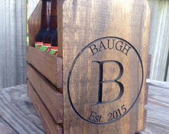 May include: Wooden beer carrier with a personalized engraved circle featuring the name "BAUGH" and the letter "B" with the text "Est. 2015".