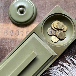 May include: A white ceramic mug with a black handle and the text "But First, Coffee" in a handwritten style. The mug is on a white surface. The mug is 4 inches tall.