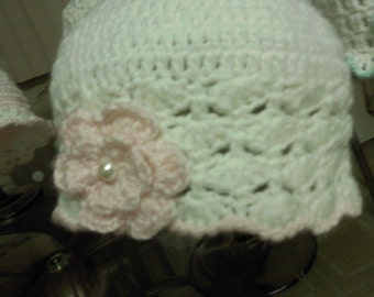 May include: White crocheted hat with a pink crocheted flower and a pearl accent.