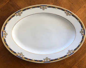Puede incluir: Plato ovalado blanco para servir con borde dorado y diseño floral azul y dorado.