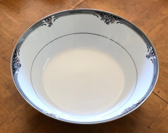 Puede incluir: Un tazón de cerámica blanco con un diseño floral negro y gris alrededor del borde. El tazón está vacío.