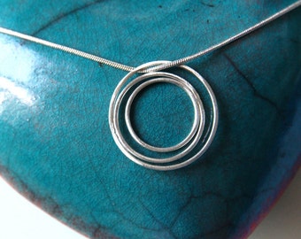 Asymmetric concentric rings silver pendant