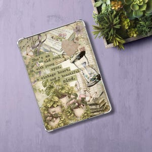 May include: A decorative tablet case with a collage design. The text reads "She's an old soul with young eyes, a vintage heart, and a beautiful mind." The design includes an hourglass, plants, books, and butterflies.