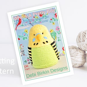 May include: Knitting pattern for a toilet roll cover featuring a yellow and green knitted parakeet with black stripes. The pattern is titled "Who's A Pretty Boy" and is by Debi Birkin Designs.