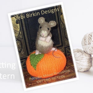 Może przedstawiać: Wzór na szydełkowanie poduszki na szpilki w kształcie dyni z małą szarą myszką siedzącą na górze. Wzór nosi tytuł "Pumpkin Mouse Pincushion Knitting Pattern".