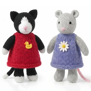 May include: Two knitted stuffed animals: a black and white cat wearing a red dress with a yellow duck button, and a gray mouse wearing a purple dress with a white daisy button. Both figures have embroidered pink noses and black bead eyes.