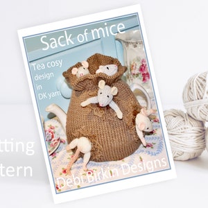 Può includere: Schema di lavoro a maglia per un copri-teiera a forma di sacco di topi. Il copri-teiera è marrone e i topi sono bianchi. Lo schema si chiama "Sack of Mice" ed è di Debi Bkkn Designs.
