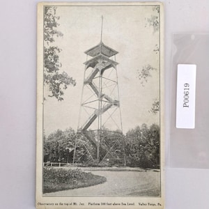 May include: Vintage black and white postcard featuring an observatory tower with exterior staircases. The tower is set against a backdrop of trees and a winding path. Text at the bottom reads: Observatory on the top of Mt. Joy. Platform 500 feet above Sea Level Valley Forge, Pa.
