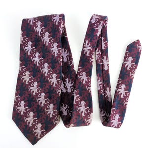 May include: A burgundy silk tie with a repeating pattern of pink and black octopus silhouettes.