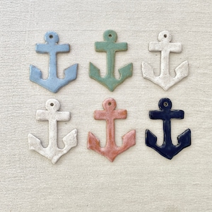 May include: Six ceramic anchor ornaments in various colors, including blue, green, white, pink, and navy blue. Each anchor has a speckled glaze finish.