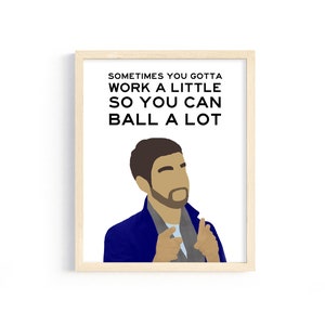 May include: A framed print with a white background and black text that reads "Sometimes you gotta work a little so you can ball a lot". A cartoon illustration of a man with brown hair and a beard wearing a blue jacket is in the bottom right corner of the print.