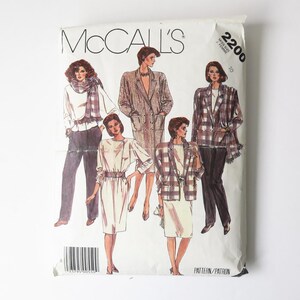 Peut inclure: Une enveloppe de patron de couture vintage McCall's avec des illustrations de modèles de mode féminine. Les modèles comprennent des blazers, des robes et des tailleurs-pantalons. L'enveloppe est blanche avec le logo McCall's et le numéro de modèle 2200.
