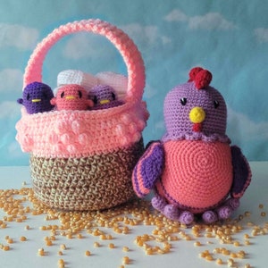 May include: A crocheted pink and purple chicken toy with a yellow beak and a pink crocheted basket filled with crocheted chicks and white yarn.