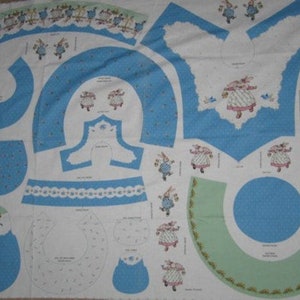 May include: A fabric panel with a blue and white pattern featuring a bunny rabbit wearing a dress and holding a bird. The panel includes multiple pieces for sewing a bunny rabbit costume. The text on the panel reads "Bunny Hat Panel - Accessories for the Bunny Hat."