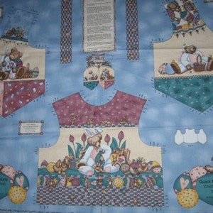 May include: A blue fabric panel with a patchwork design featuring various images of bears, bunnies, and eggs. The panel includes instructions for a "Quick 'n Easy Child Vest" project.